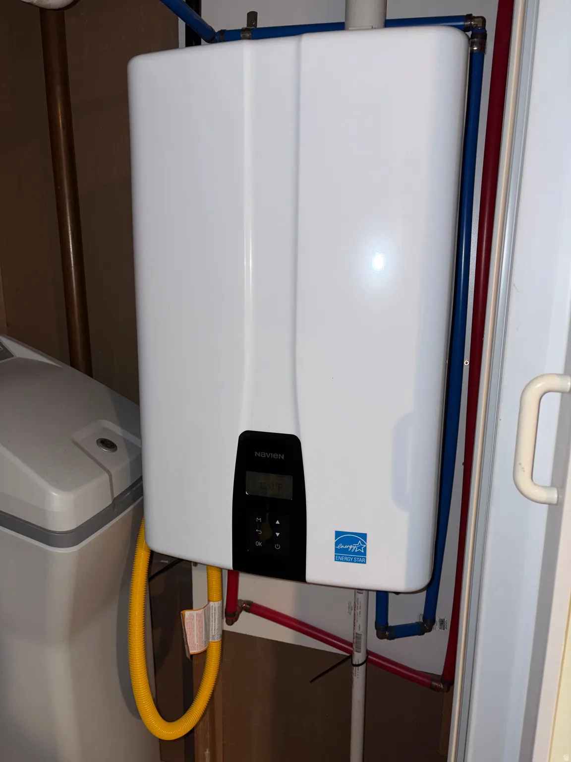 Tankless water heater installation featuring exposed PEX plumbing lines