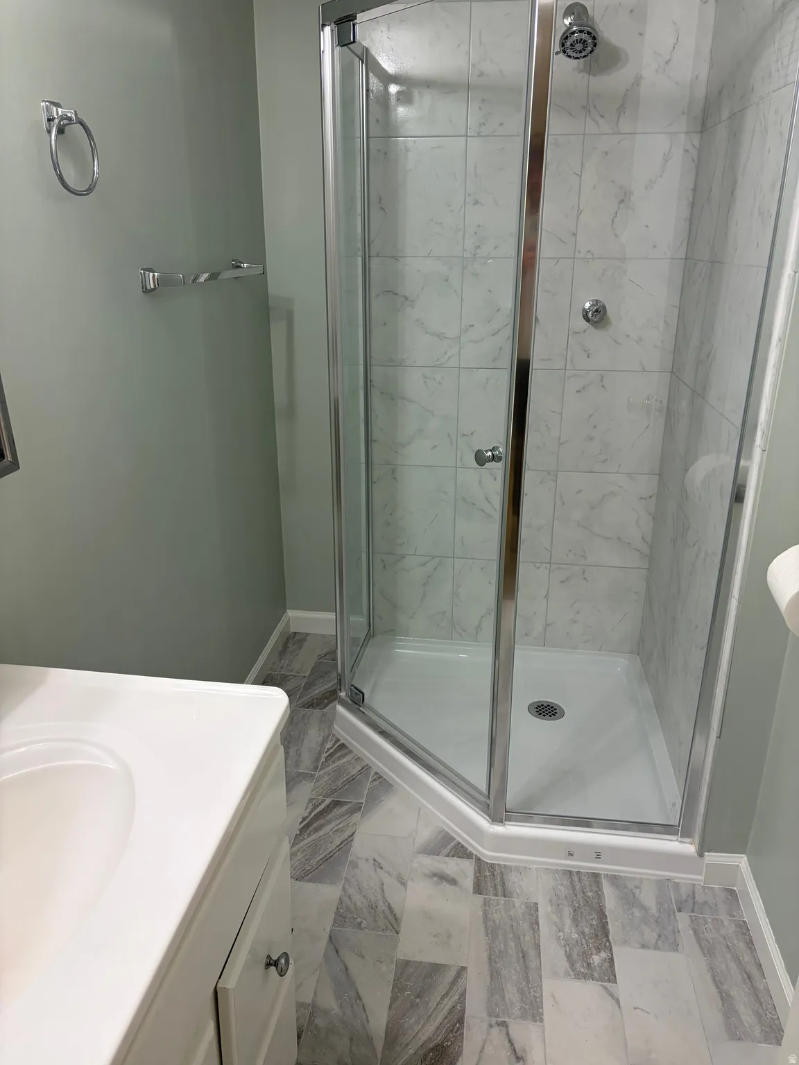 Corner shower enclosure with clear glass panels and chrome hardware