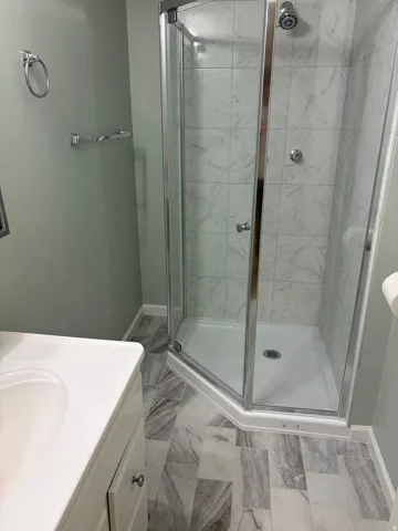 Corner shower enclosure with clear glass panels and chrome hardware