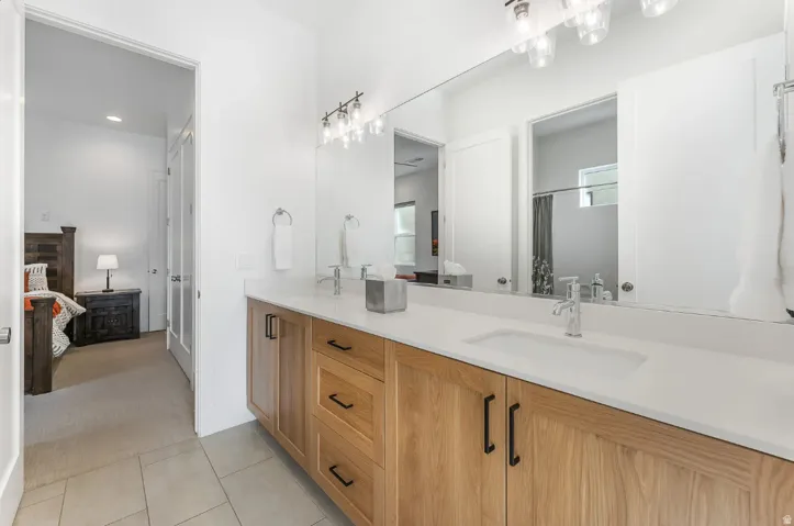 Double vanity featuring light wood-finish cabinetry and white countertops