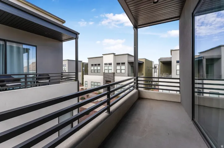 Private balcony featuring contemporary black metal railings and a concrete surface