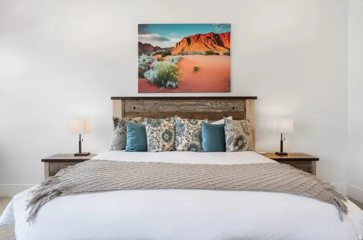 Bedroom featuring a wood-finish headboard, matching wood-finish side tables, and light-toned walls