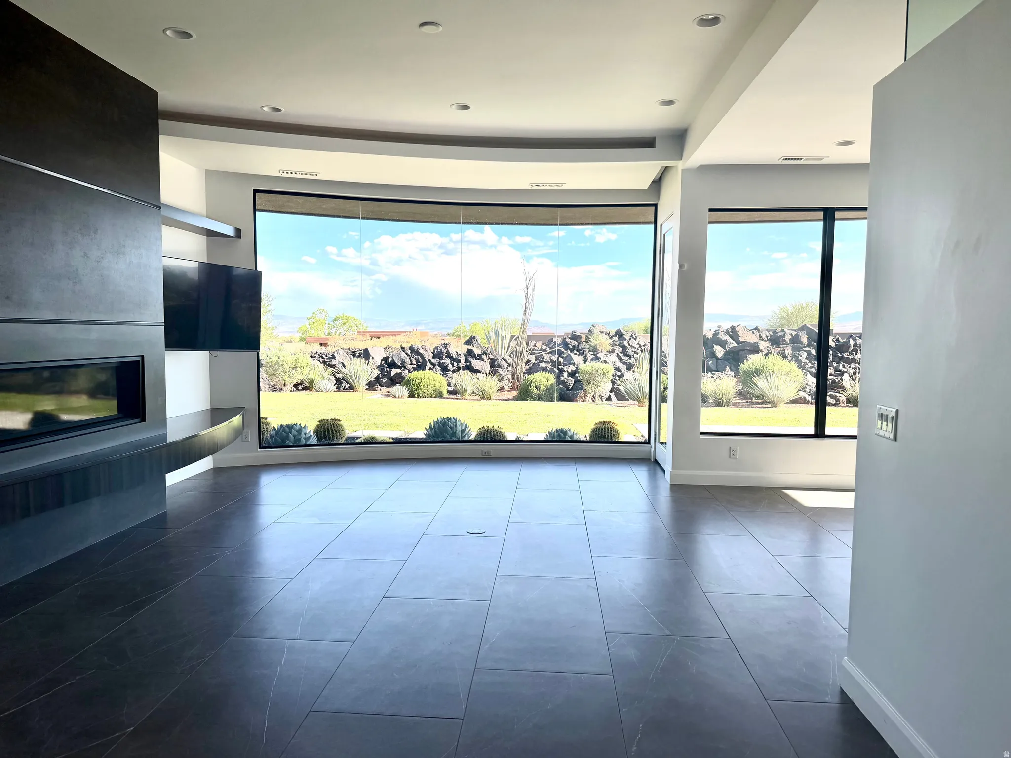 Curved window wall showcasing exterior landscaping and distant hills