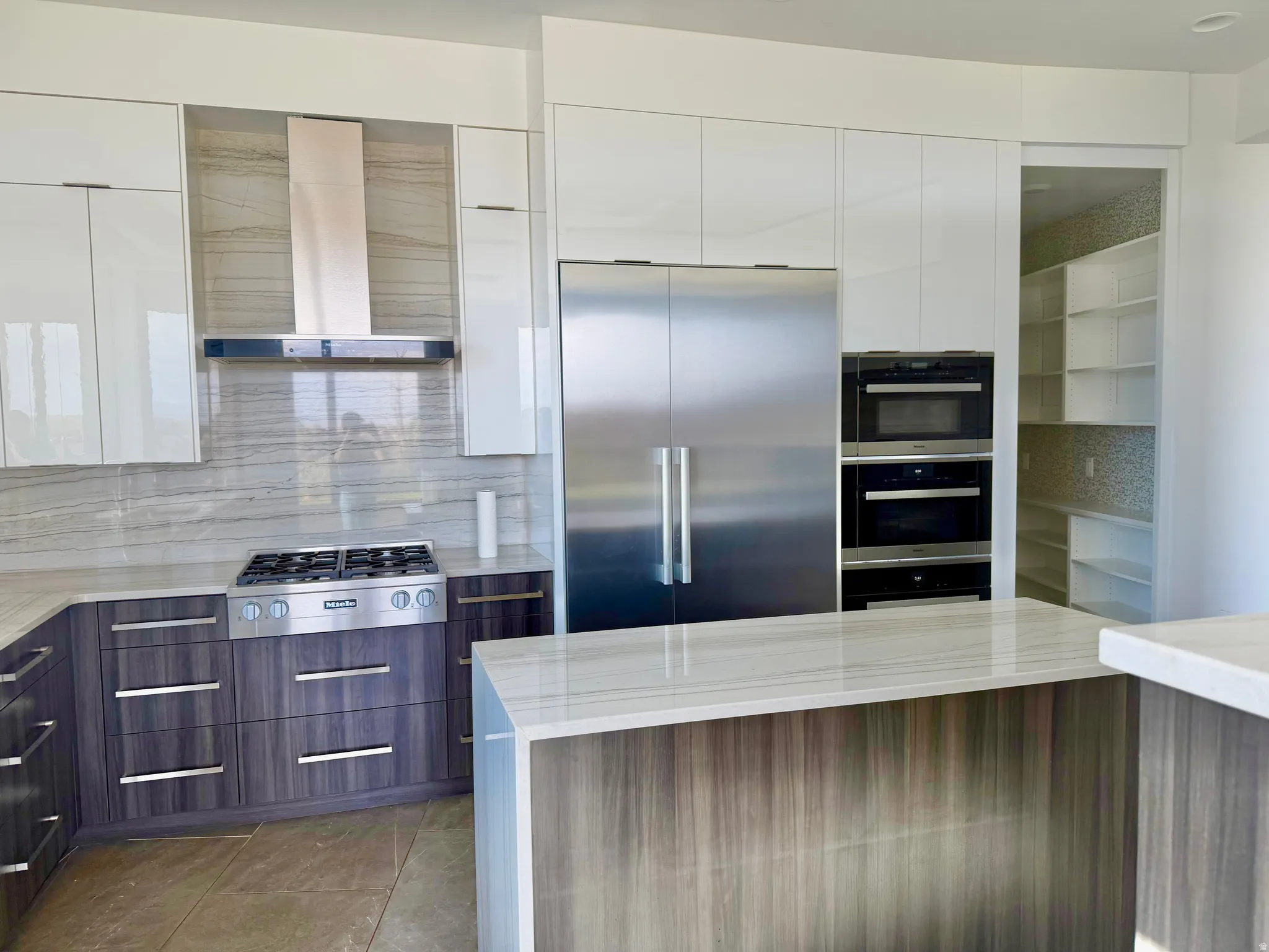 Modern kitchen featuring high-gloss white upper cabinetry and wood-finish lower cabinetry