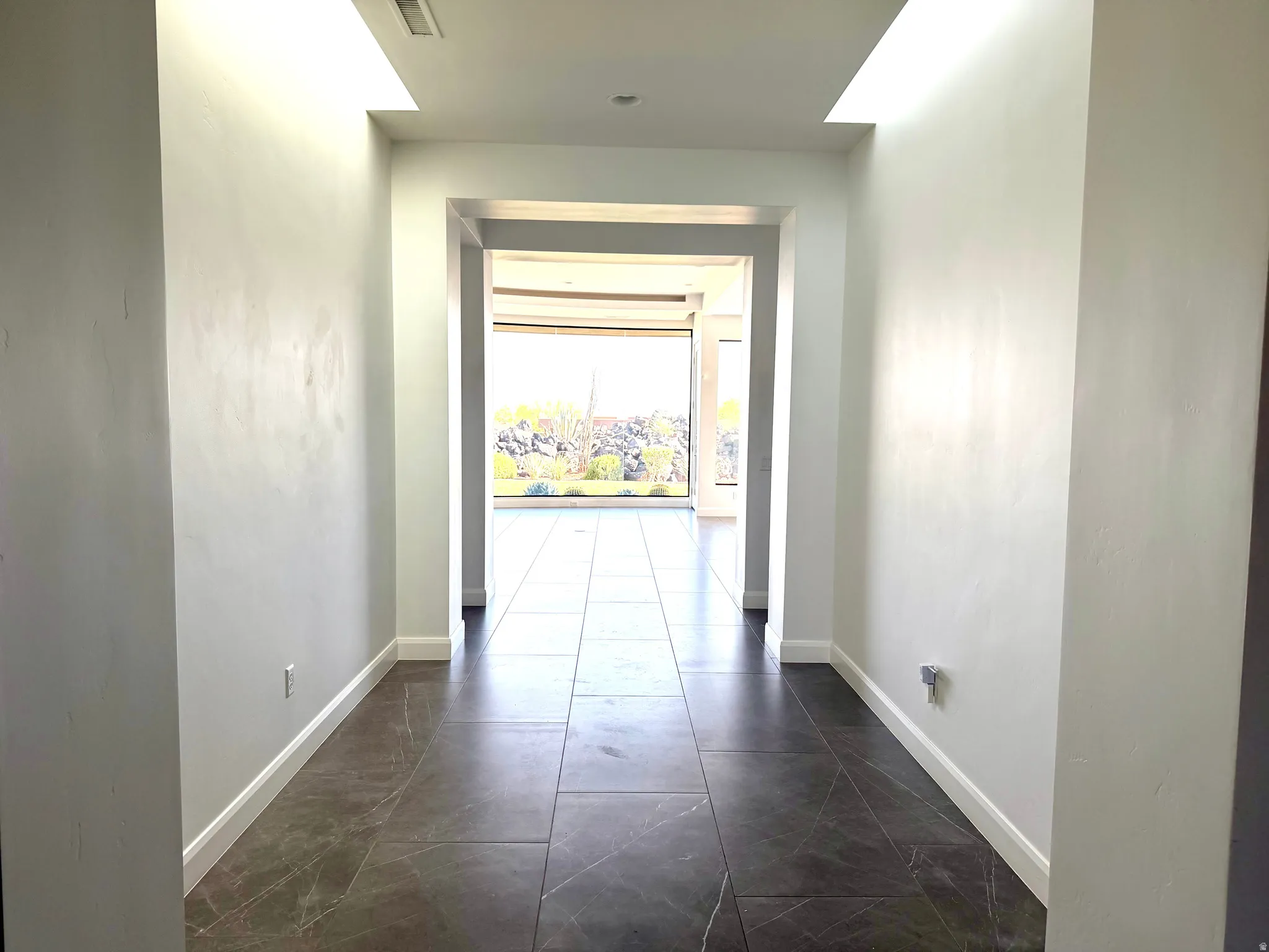 Entryway featuring large format tile flooring and white baseboards