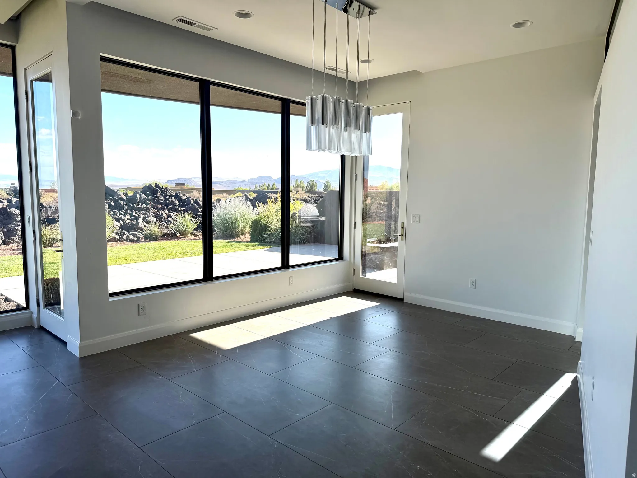 Spacious interior featuring large format tile flooring and a modern linear chandelier