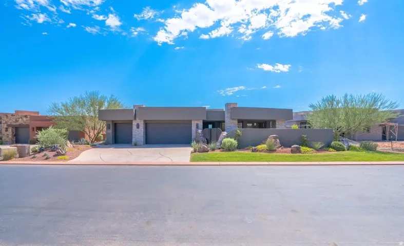 Contemporary exterior with a flat roofline, stone accents, and a dual garage