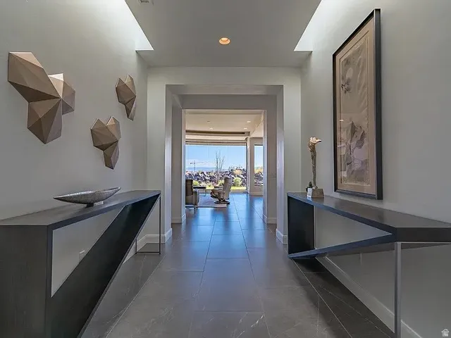 Entryway featuring large format tile flooring, recessed lighting, and wall-mounted sculptural elements