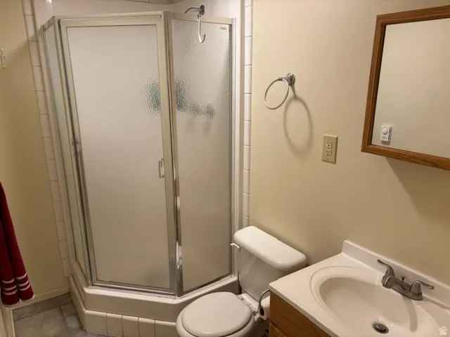3/4 bath down with a corner shower enclosure with frosted glass panels