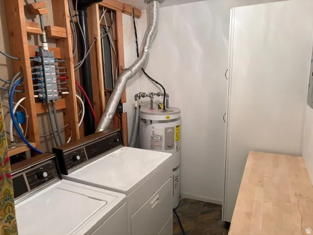Dedicated laundry area and mechanical room with water heater, electrical breaker box and a built-in white cabinet and wood counter