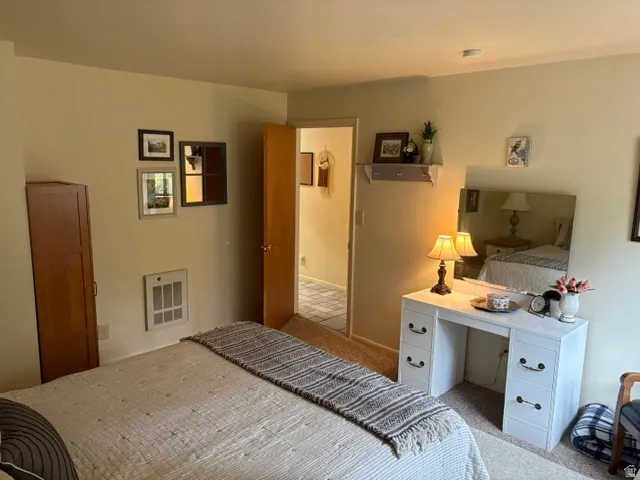 Primary bedroom with a desk and built-in wall heat register