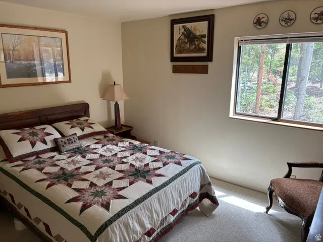 2nd main level bedroom with a view of the pines from the window