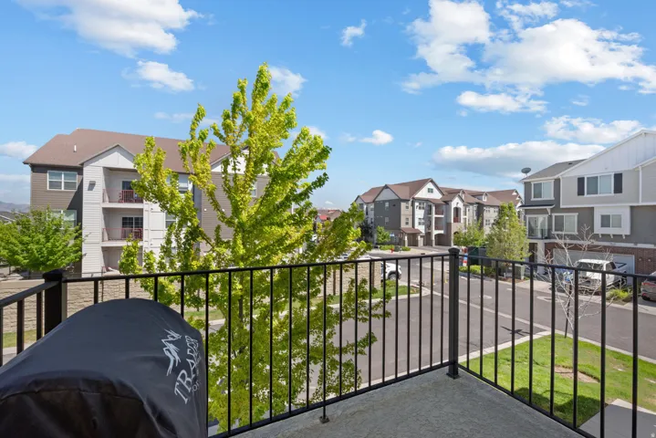 Private balcony with a black metal railing and concrete flooring