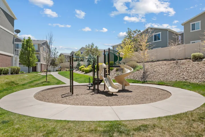 Community playground featuring a spiral slide, swing set, and ground-level slide
