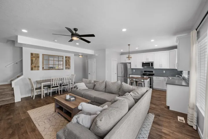 Open-concept living area with wood-finish flooring, recessed lighting, and a modern ceiling fan