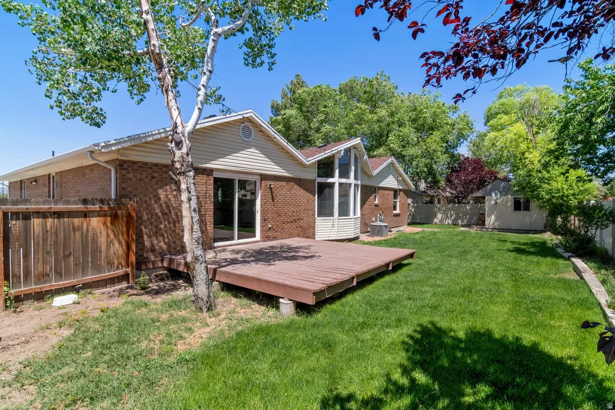 Expansive backyard featuring a large wood deck and a manicured lawn