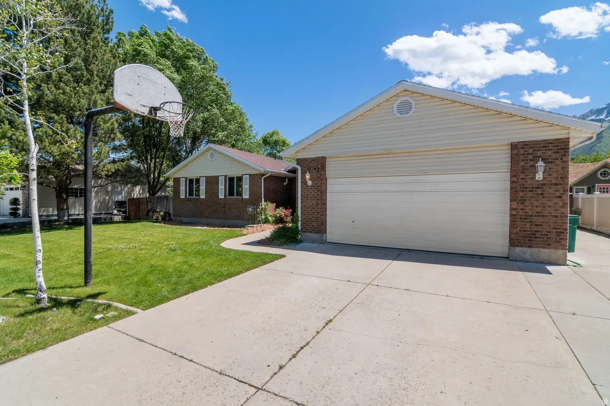 Spacious concrete driveway leading to a two-car garage