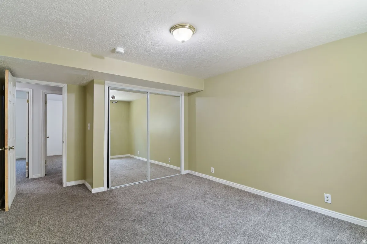 Spacious room featuring neutral carpeting and light-toned walls