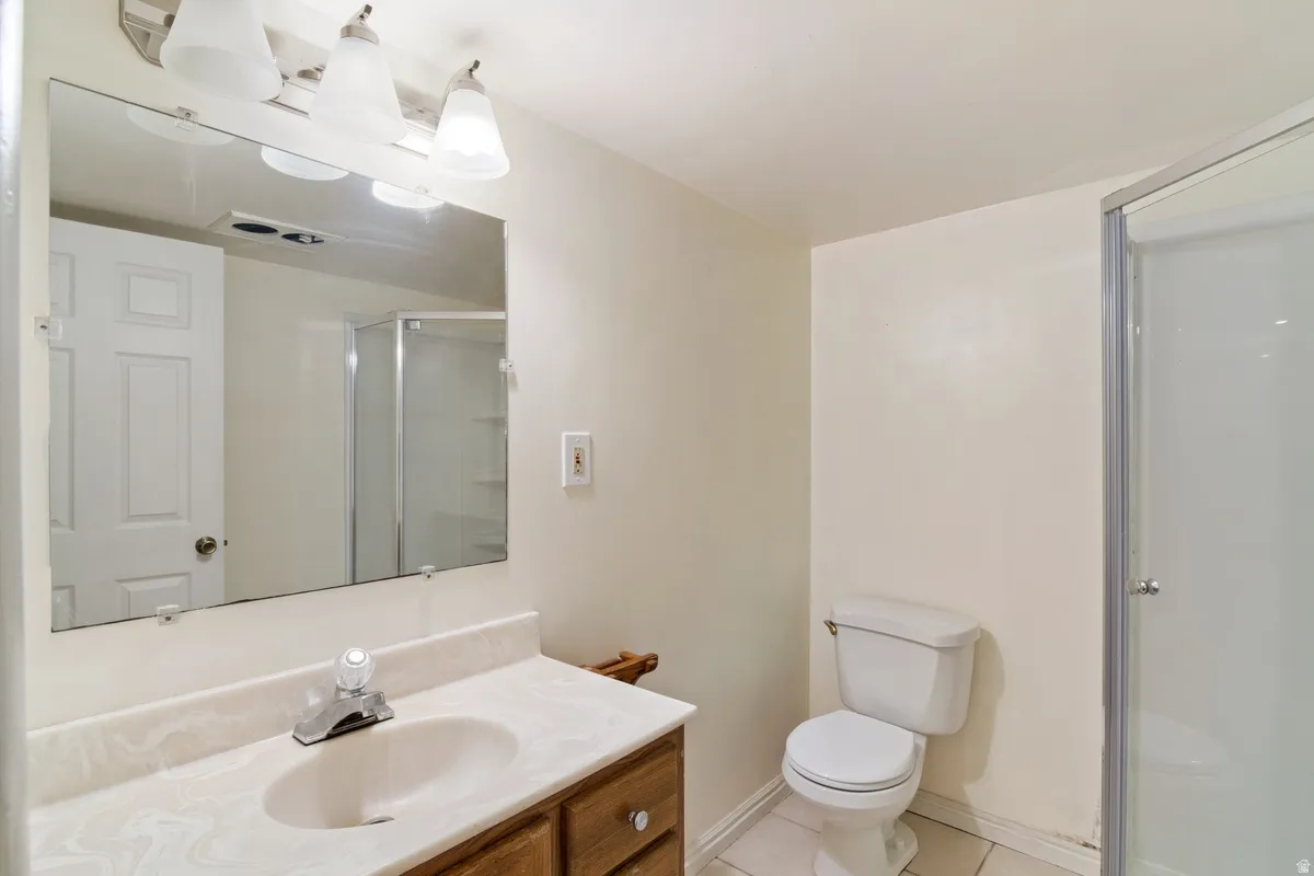 Bathroom featuring a wood-finish vanity with an integrated sink and a white countertop
