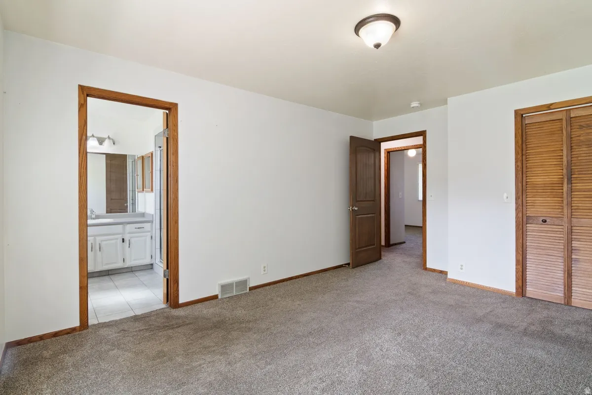 Carpeted room with white walls, wood trim, and a semi-flush mount ceiling light
