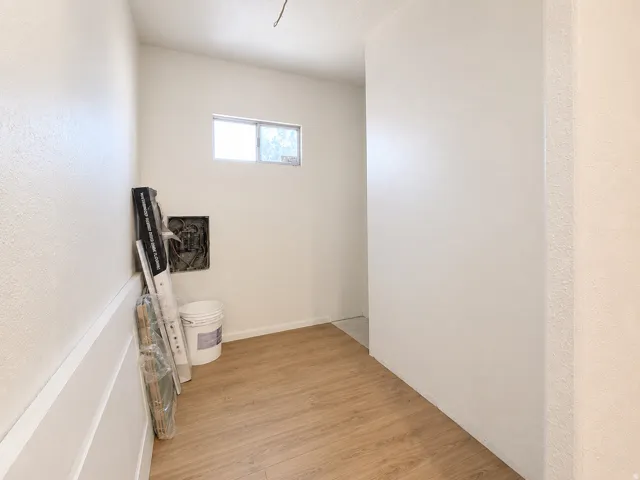 Room featuring wood-finish flooring, a window providing natural light, and freshly painted walls