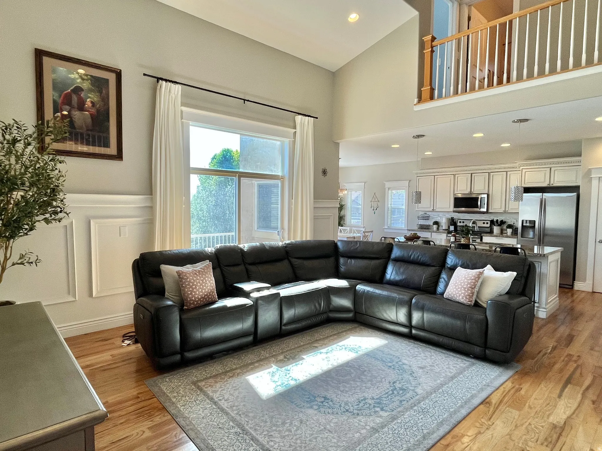 Great room with soaring ceilings, hardwood flooring, and abundant natural light