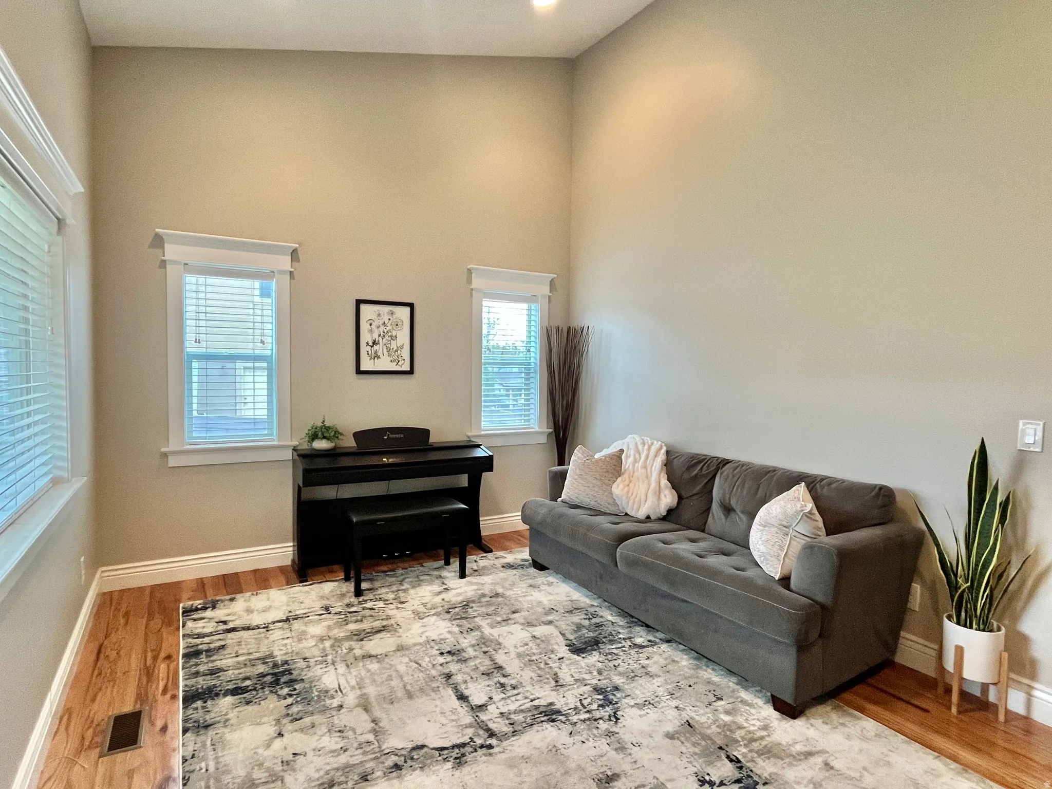 Living space featuring high ceilings, recessed lighting, and wood-finish flooring