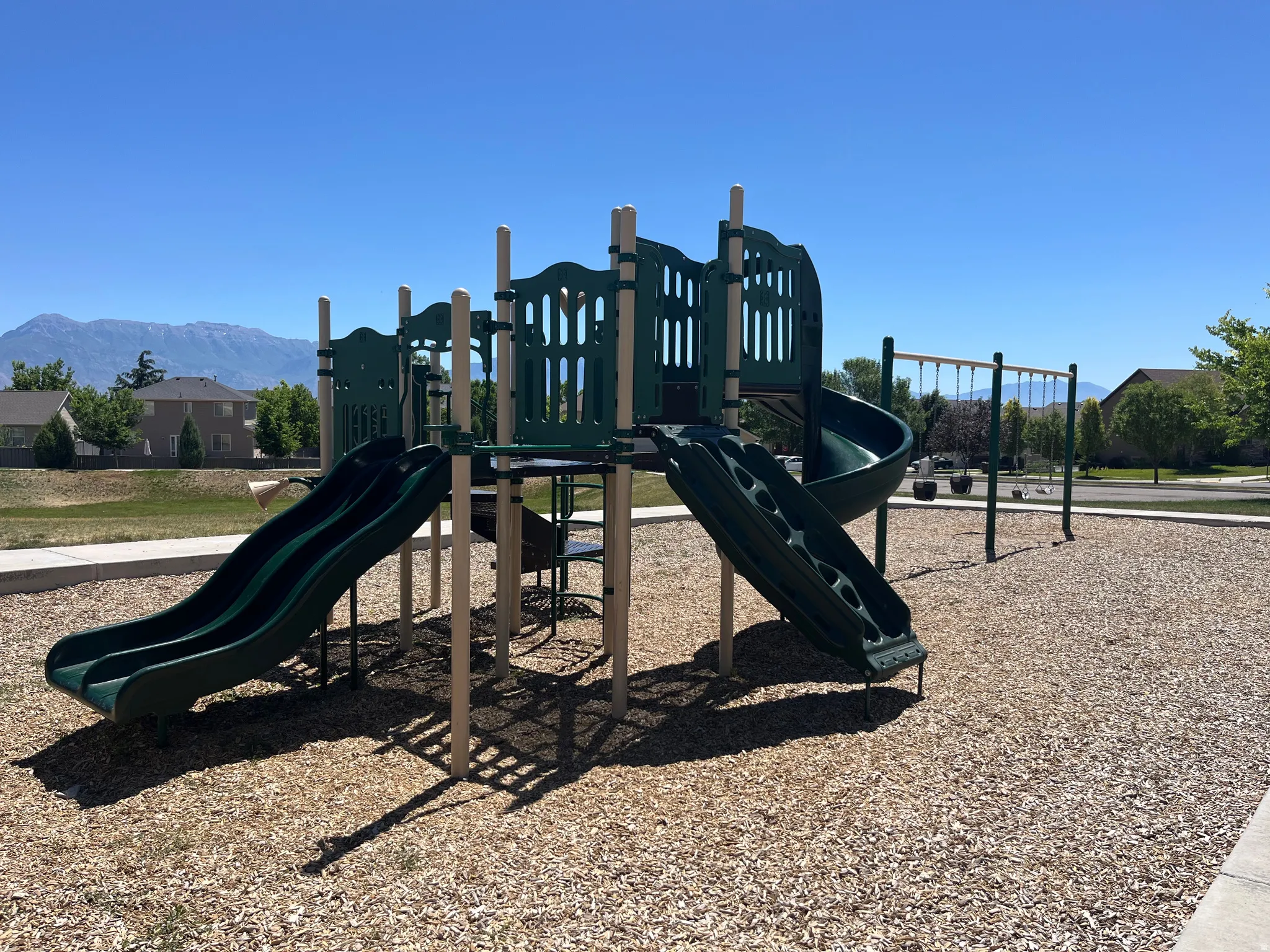 Community playground just a few steps away, featuring multiple slides and swings
