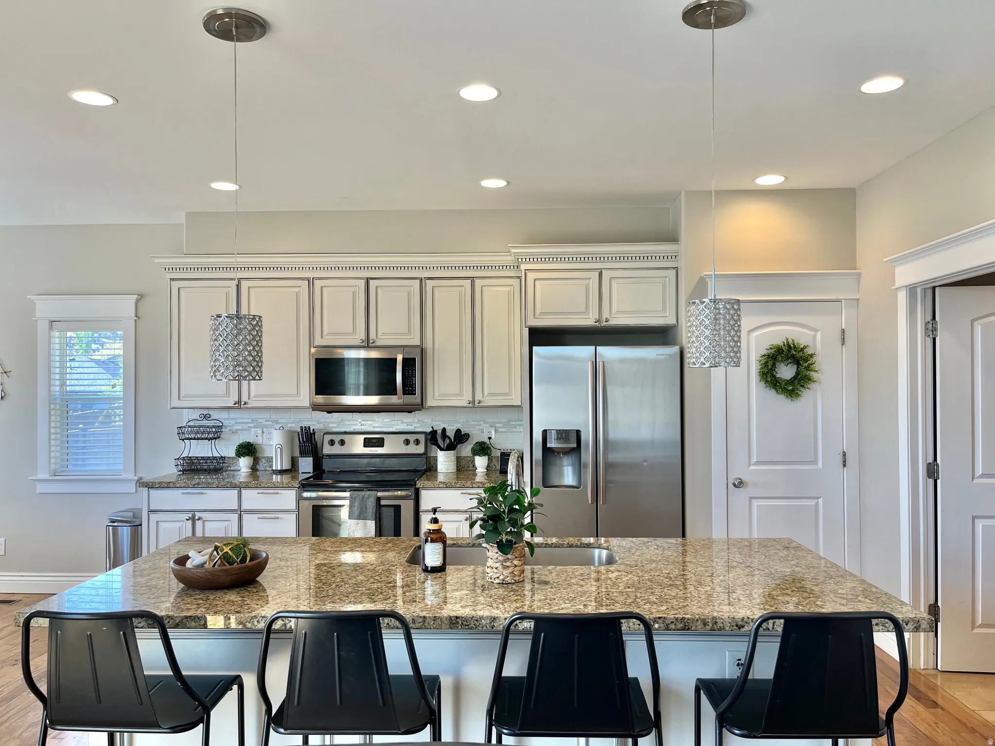 Open-concept kitchen featuring an expansive granite countertop island with seating