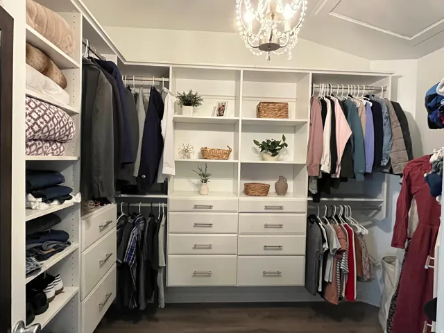 Custom closet system featuring white cabinetry, multiple hanging rods, and integrated shelving