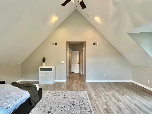 Vaulted ceiling room featuring light-toned wood-finish flooring, recessed lighting, and a ceiling fan