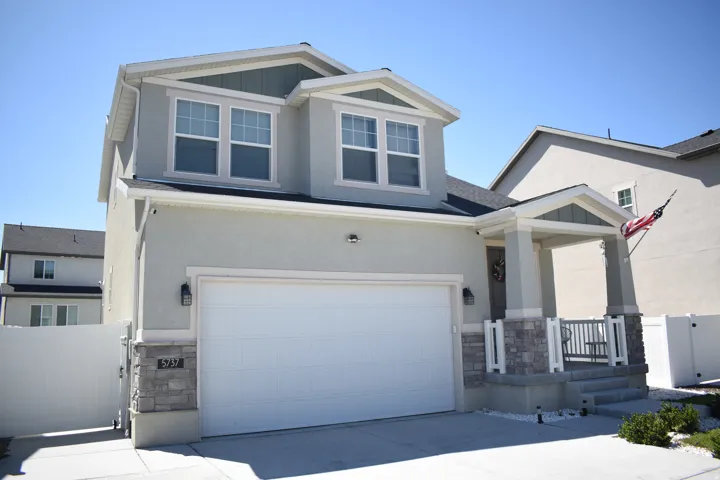 Two-story residence featuring a front-facing garage with a white door