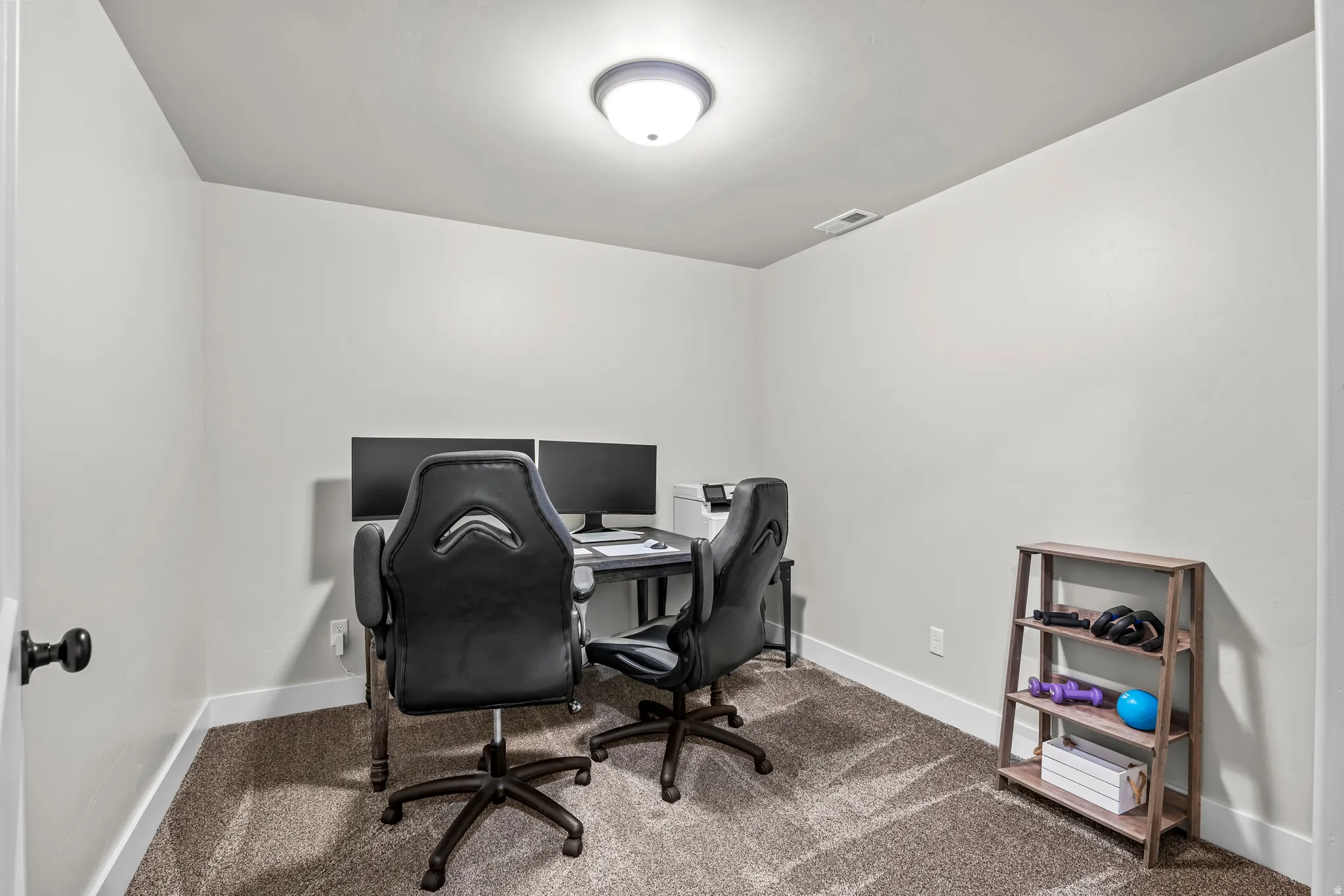 Versatile room featuring light neutral wall paint, white trim, and a textured carpeted floor