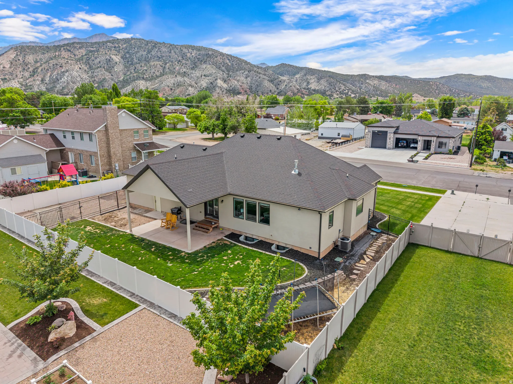 Rear exterior featuring a covered patio, a manicured lawn, and a privacy fence