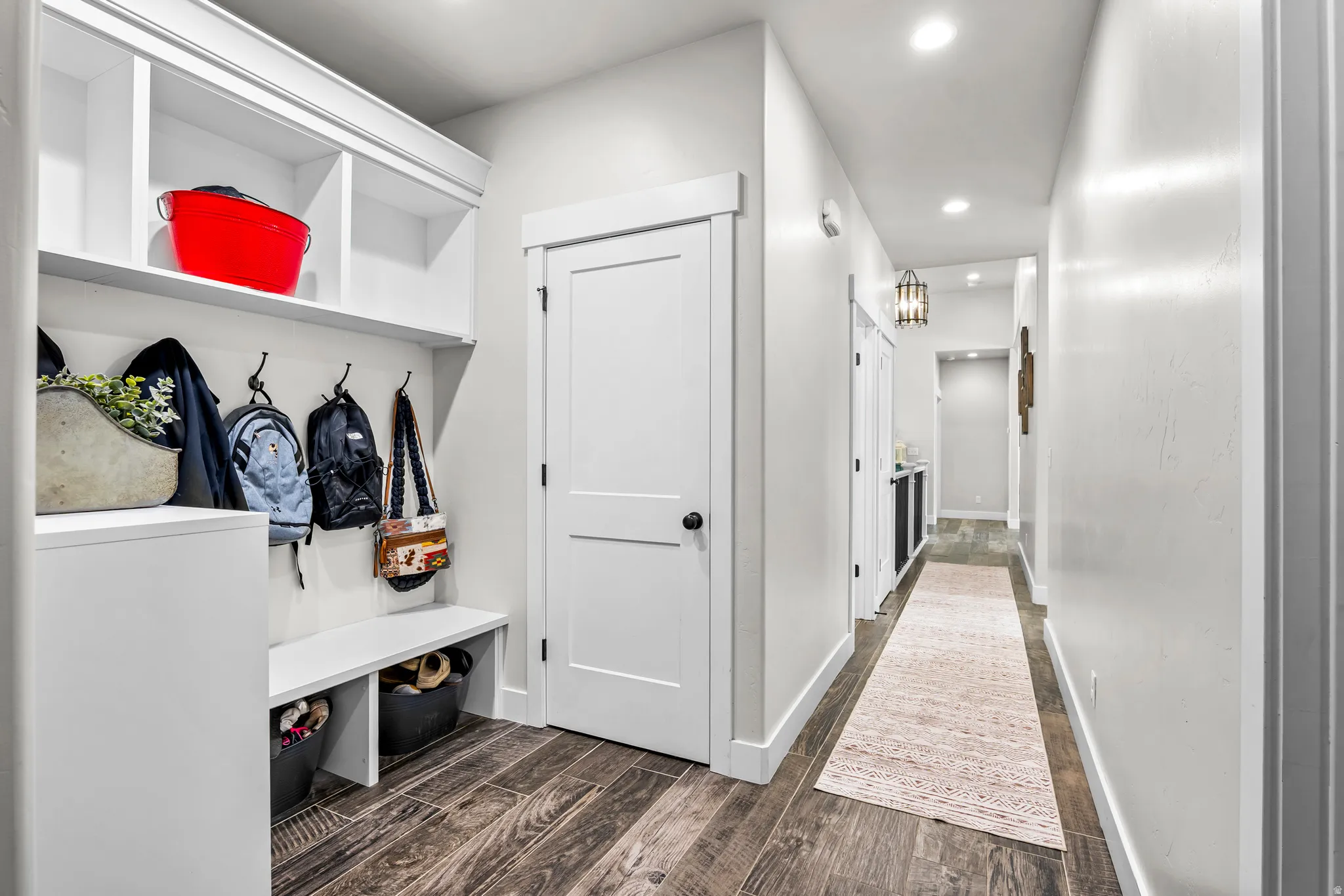 Built-in mudroom storage featuring an integrated bench, overhead cubbies, and wall-mounted hooks