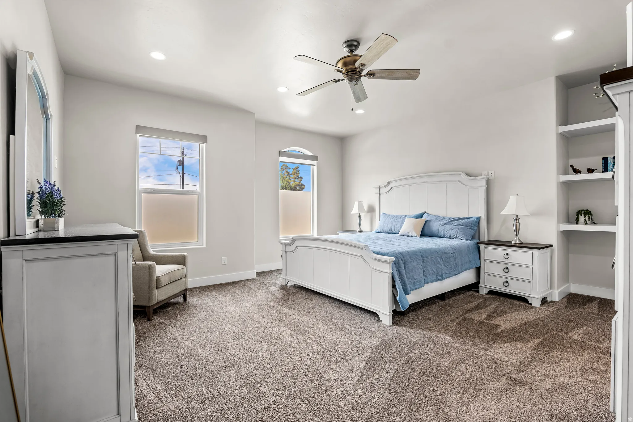 Carpeted room featuring a ceiling fan, recessed lighting, and two windows with blinds