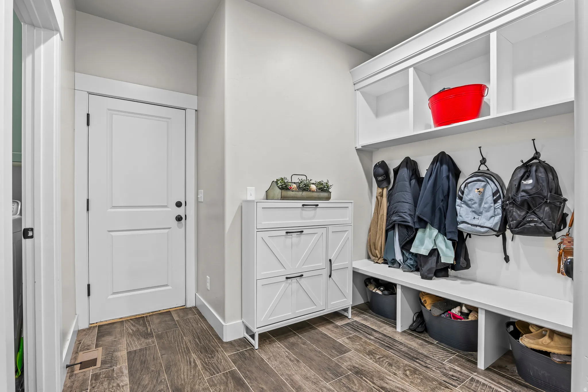 Mudroom with built-in cubby storage, bench seating, and wood-finish flooring