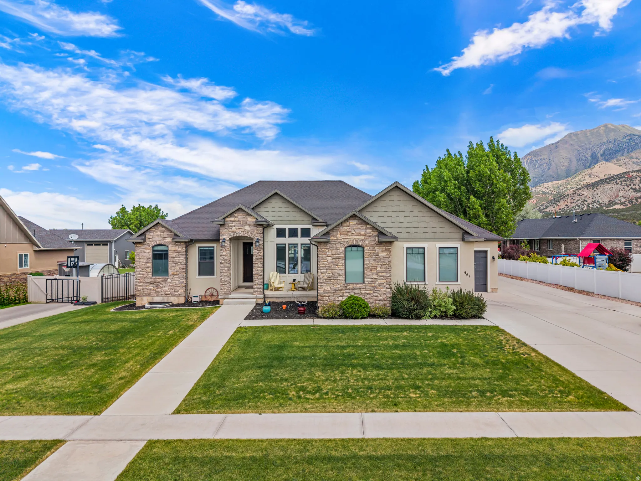 Stone and stucco exterior residence featuring an arched portico entryway
