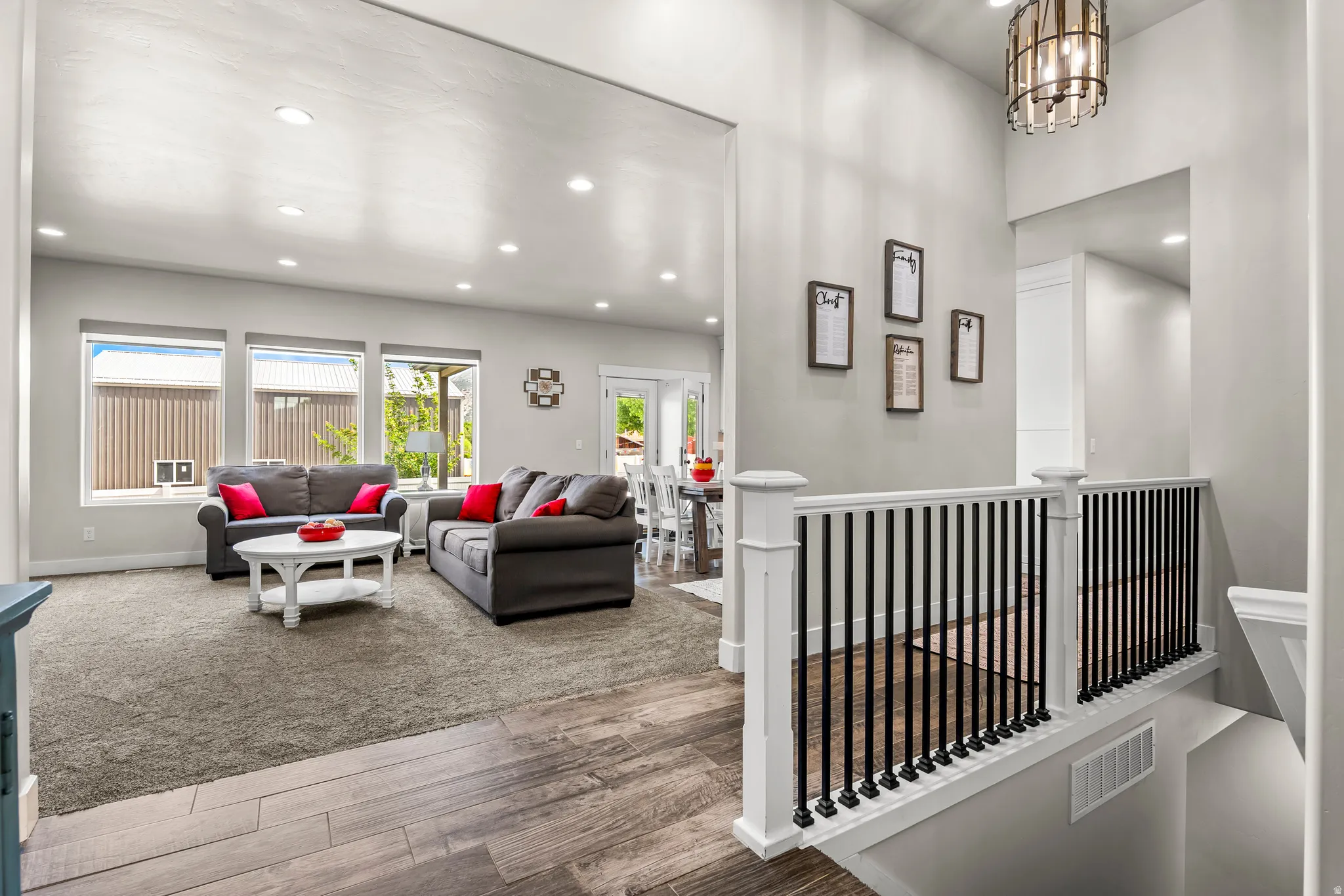 Open-concept living area featuring wood-finish flooring, recessed lighting, and a neutral color palette