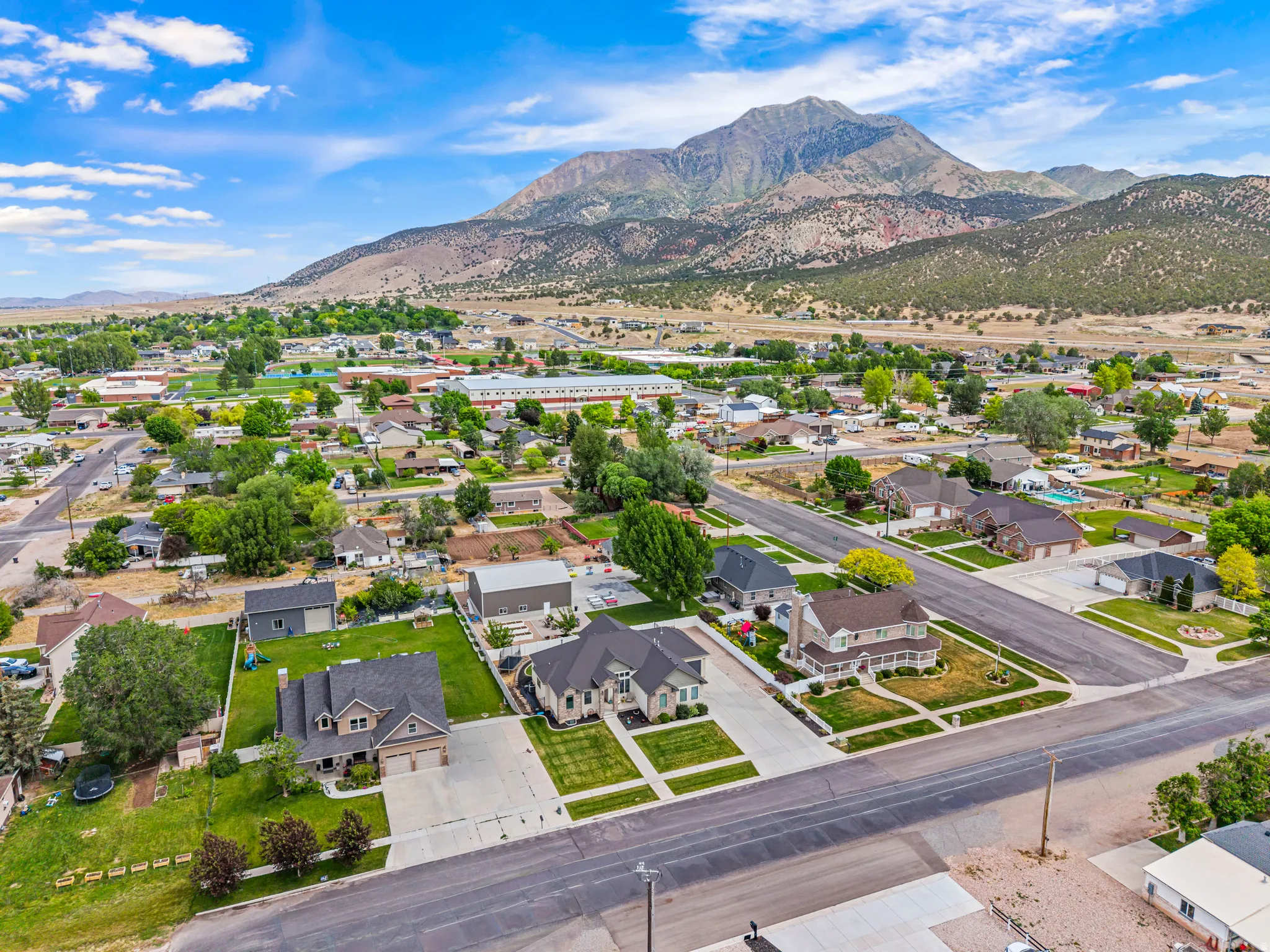 Community setting with mountainous backdrop, tree-lined streets, and residential properties