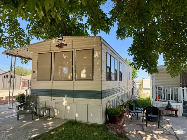 Exterior featuring horizontal siding, multiple window units, a side patio, and a covered front porch