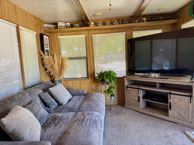 Wood-paneled room with multiple windows and a built-in display shelf