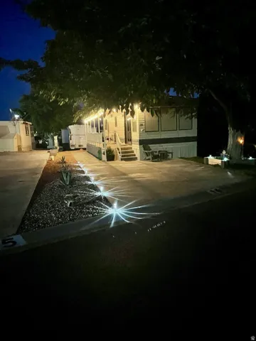Illuminated exterior with a covered porch featuring string lights