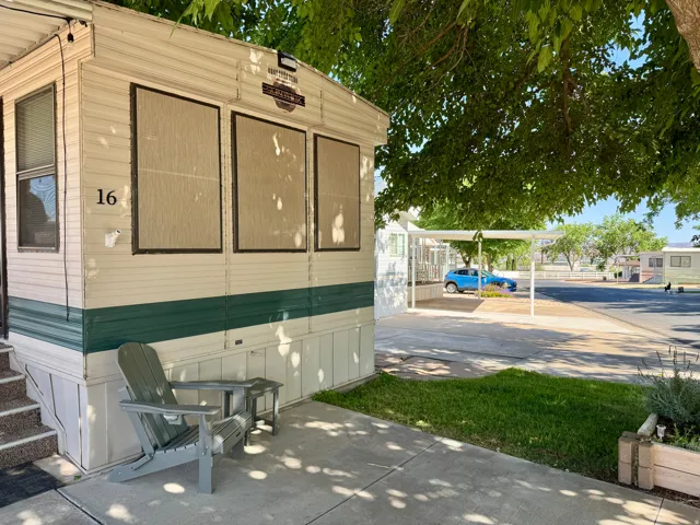 Mobile home exterior featuring horizontal siding, a covered patio area, and an adjacent carport