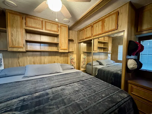 Bedroom featuring wood-finish wall panels and extensive built-in cabinetry