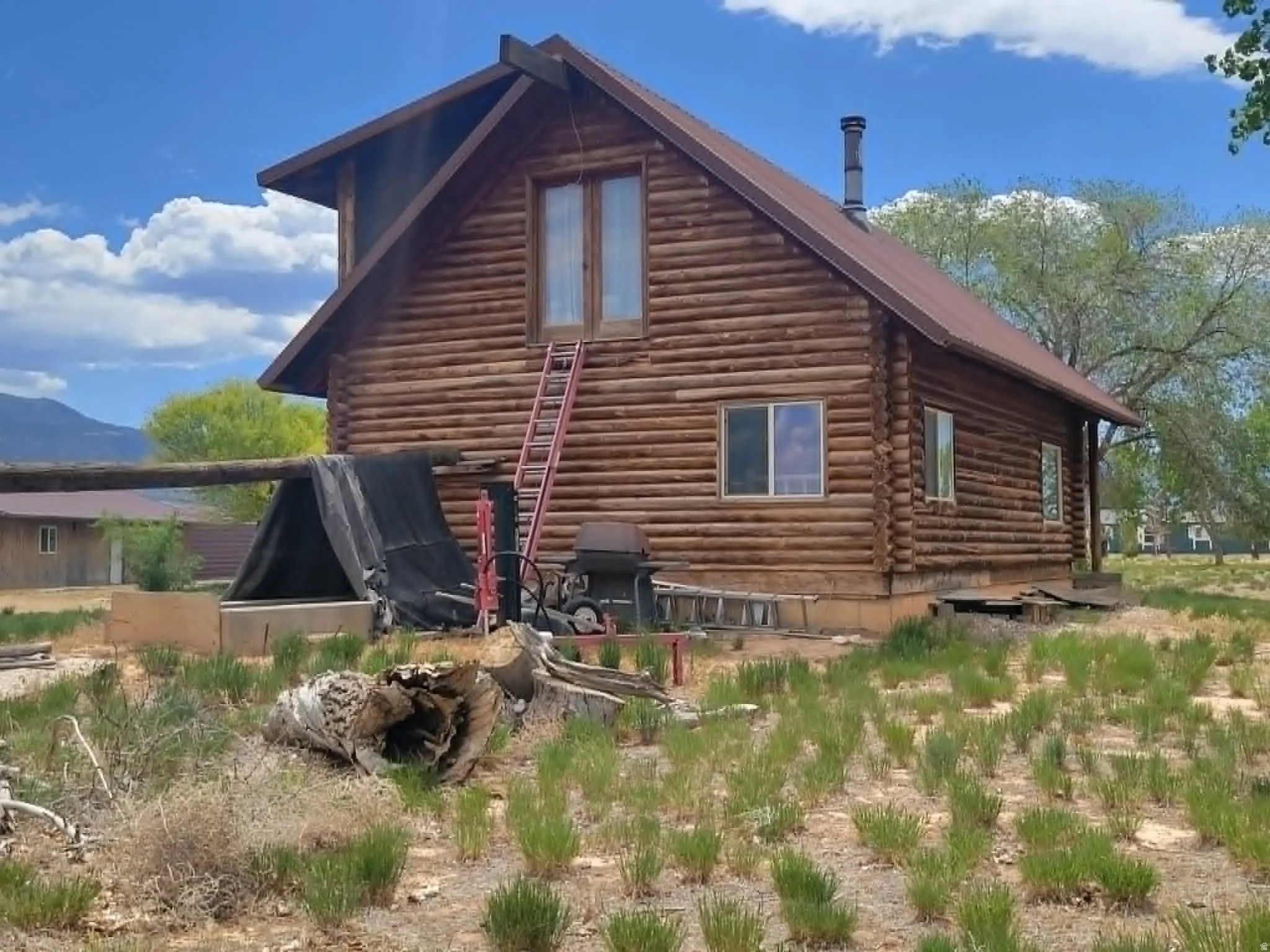 Log cabin-style exterior with a gable roof and visible window dormer