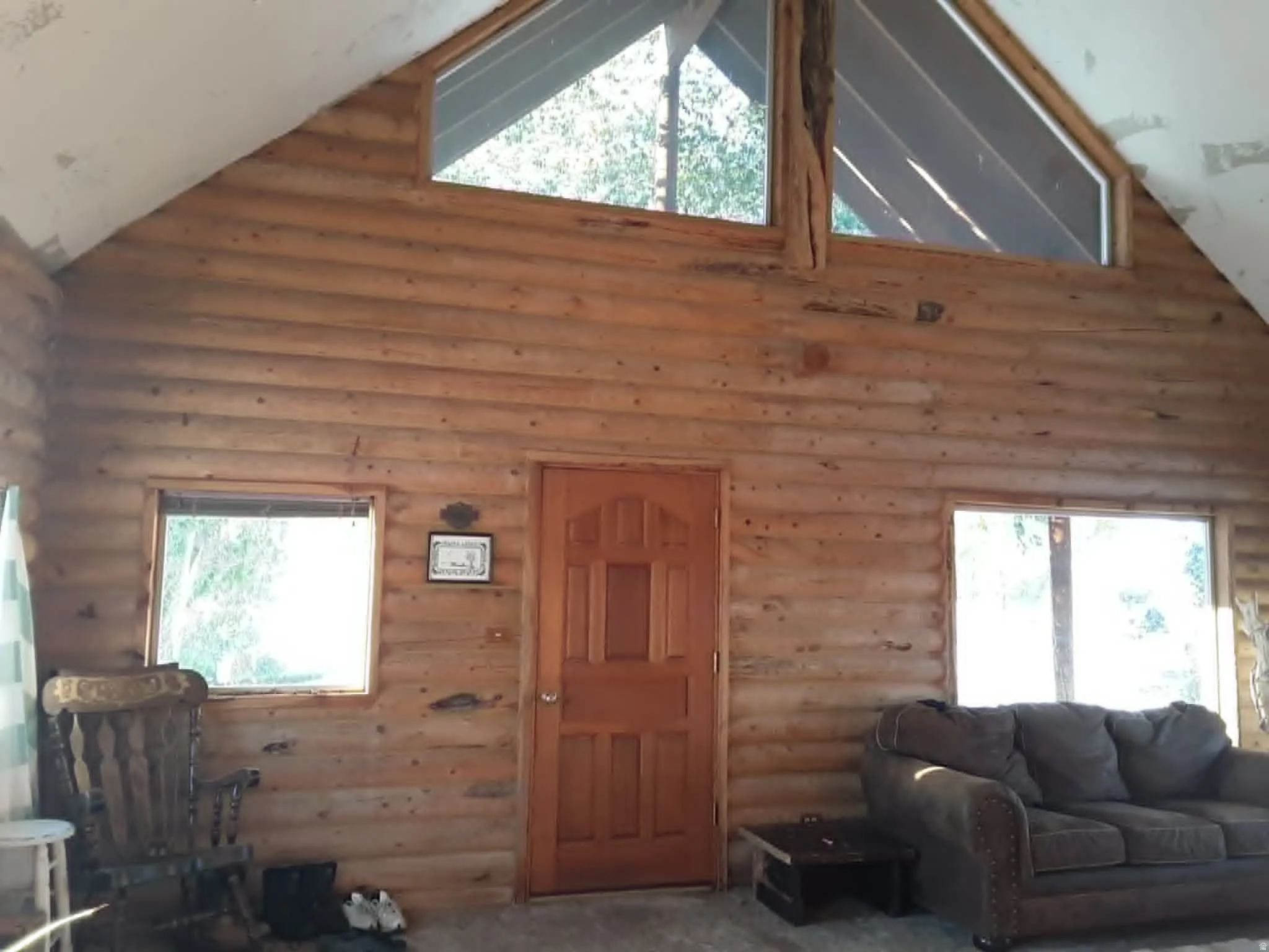 Log cabin interior featuring natural wood walls and a vaulted ceiling