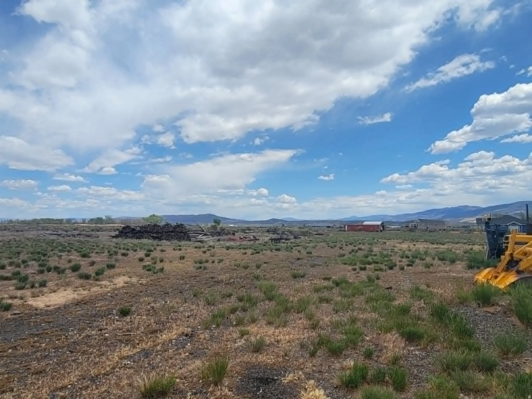 Expansive undeveloped land featuring natural vegetation and distant mountain ranges
