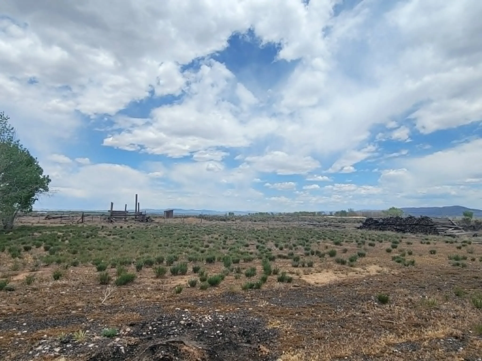 Expansive land parcel featuring natural ground cover and distant mountain ranges