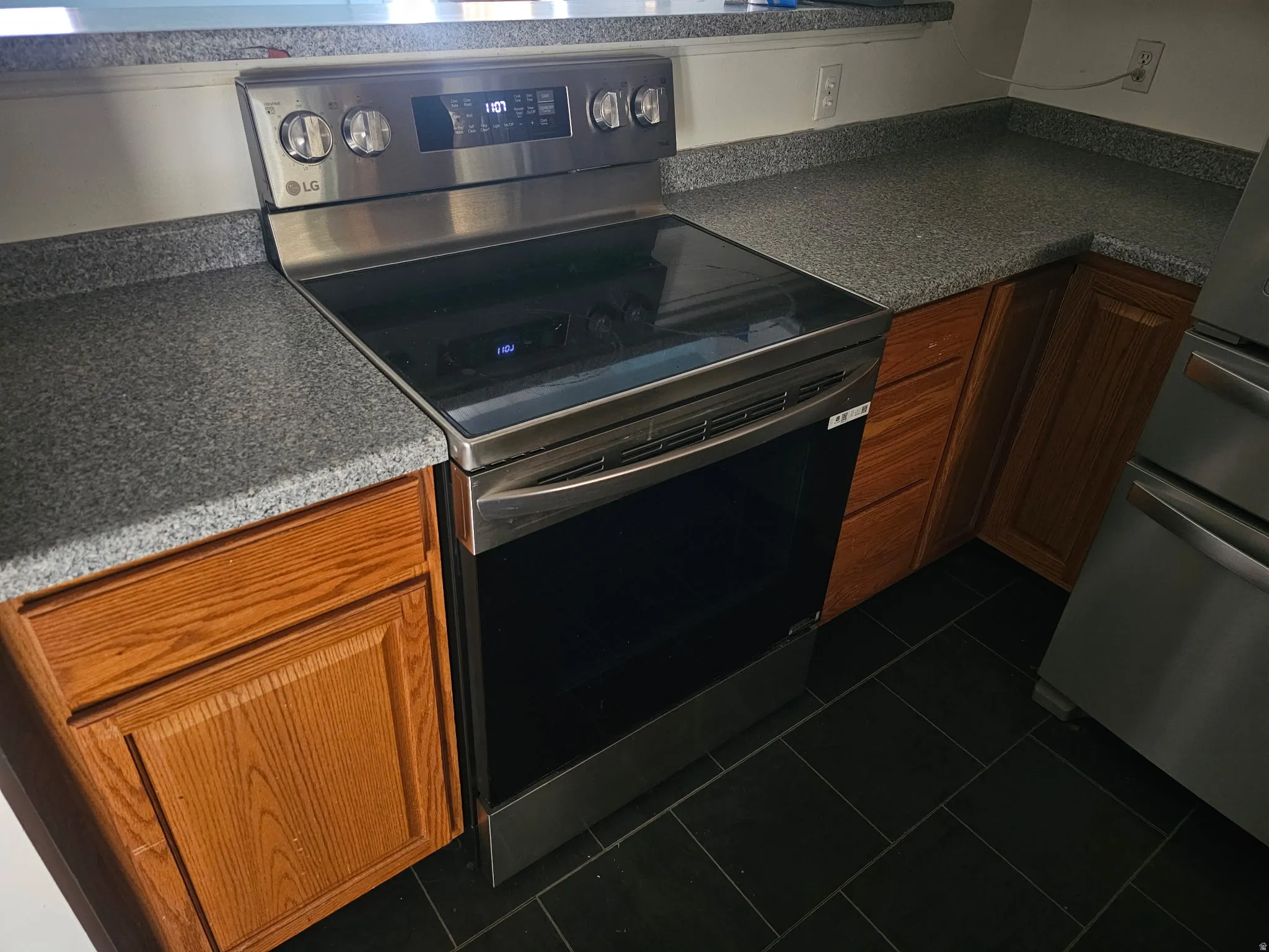 Stainless steel range with a black glass cooktop and digital controls